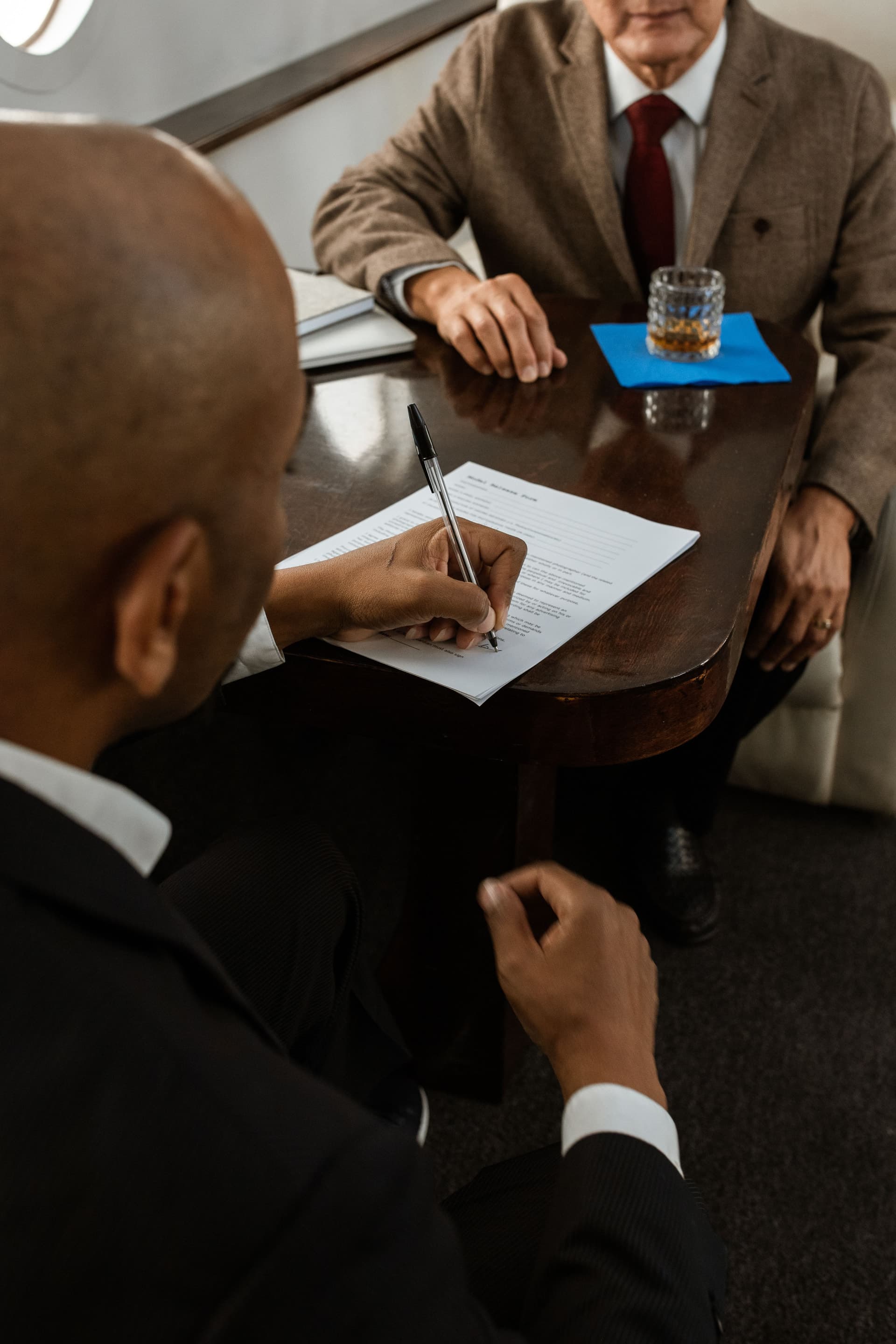Two people reviewing paperwork at a table inside an aircraft cabin